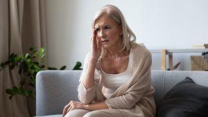 unhappy,mature,woman,touching,head,,feeling,strong,dizzy, headache,,sitting,on